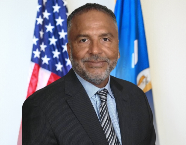 Portrait of Charles D. Tillotson, Executive Director, wearing a dark suit and striped tie.