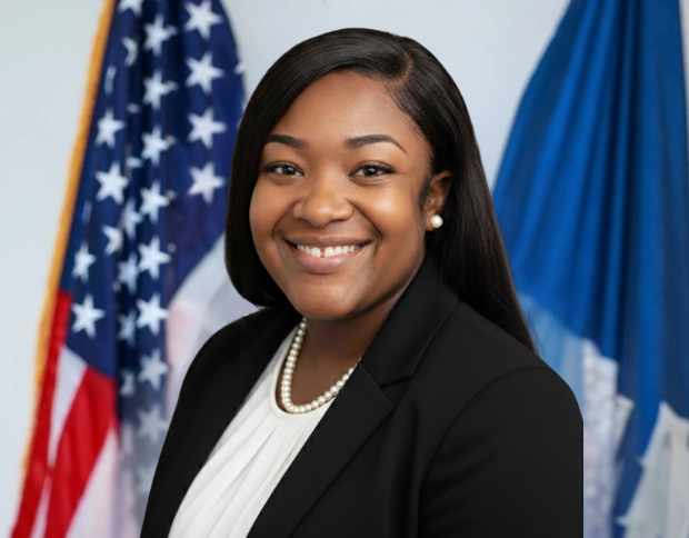 Portrait of Jasmaine Barthelemy, Legal Assistant, smiling in a black jacket and wearing a pearl necklace.