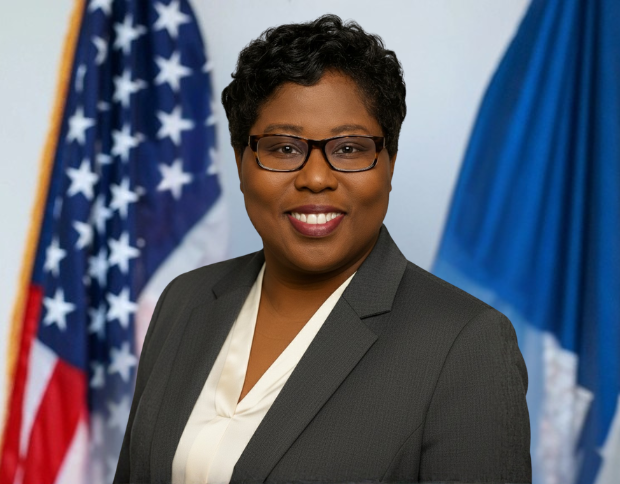 Portrait of Kimberly Weston, Senior Accountant II, smiling in a grey suit and glasses.